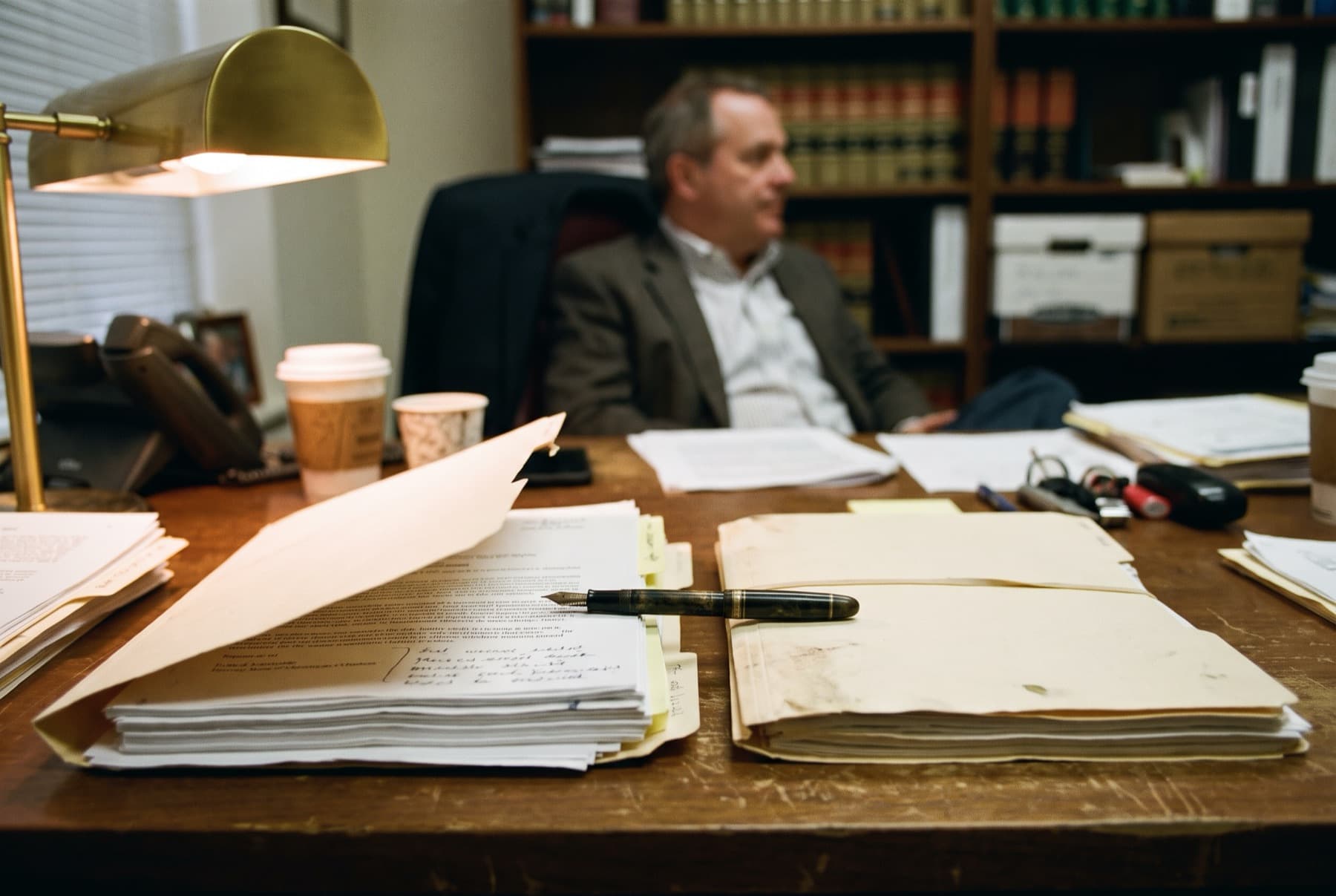 Two separate client folders lying side by side on a lawyer's desk