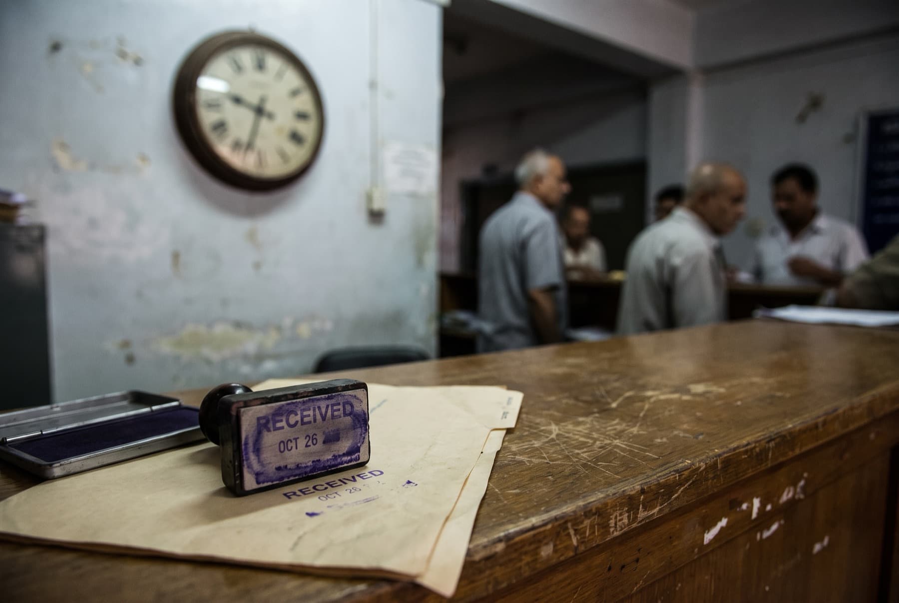 A court clerk's date stamp and a stamped document on a worn service counter